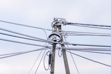 Wires on a pole in the snow. Winter background, selective focus