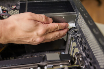 Internal parts of an old personal computer. Dusty motherboard, video card and fan. The master...