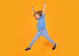 Fototapeta na wymiar Full length of excited kid jumping. Full length photo of kid boy jump high wear casual checkered shirt isolated on yellow background. Portrait of jumping boy. Kid jumping, having fun.