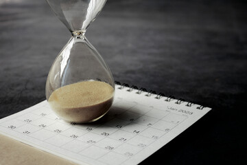 hourglass on a calendar, and flowing through the bulb of sandglass