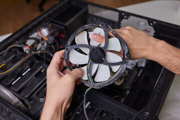 Internal parts of an old personal computer. Dusty motherboard, video card and fan. The master...