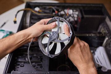 Internal parts of an old personal computer. Dusty motherboard, video card and fan. The master...