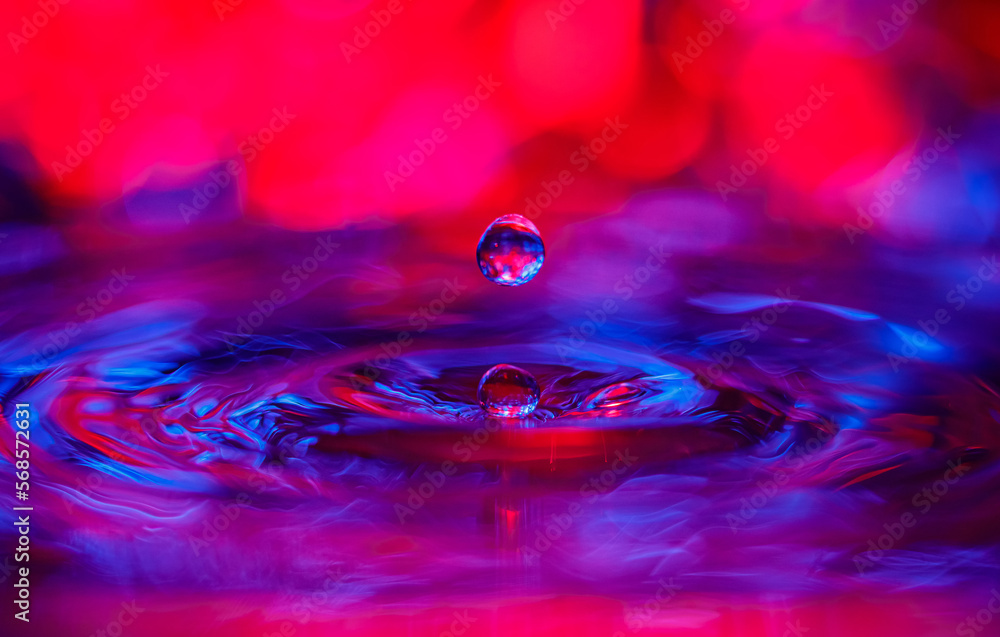 Aufkleber a transparent drop with a red-violet background falls into the water. abstract colorful background.