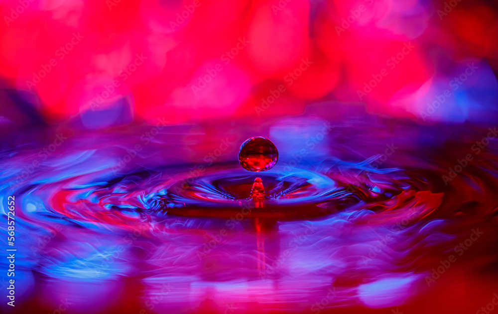 Aufkleber a transparent drop with a red-violet background falls into the water. abstract colorful background.