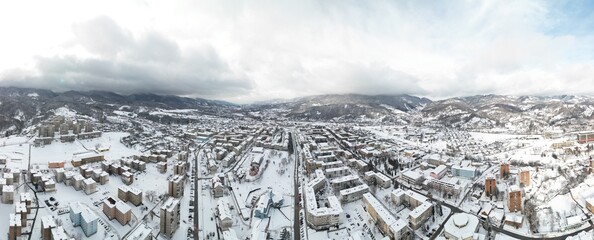 Panorama of the mountain town in winter when the fog rises