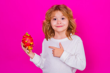 Kid hold dragon fruit in studio. Studio portrait of cute child with dragon fruit isolated on pink background, copy space.
