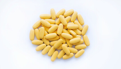 Close-up texture of yellow multivitamin tablets on white background. Healthy lifestyle concept