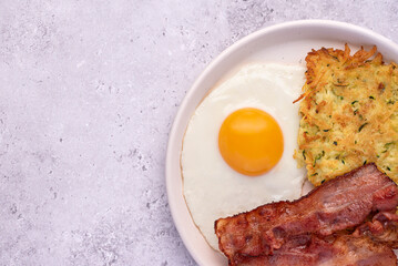 Macro food photography of fried egg, potato pancake, bacon, brunch, breakfast