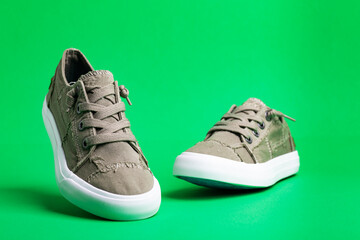 Walking shoes - sneakers. Modern fashion shoes on a green background close-up.