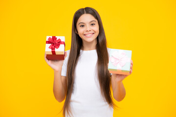 Happy teenager portrait. Smiling girl in t shirt. Teenager child holding gift box on yellow isolated background. Gift for kids birthday. Summer holiday.