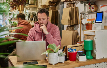Man using laptop on shop counter