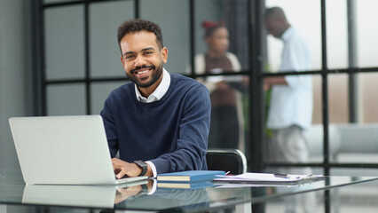 Fototapeta na wymiar African businessman working on a laptop in an office