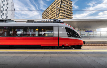 High speed train on the train station at sunset in Vienna, Austria. Beautiful red modern intercity...