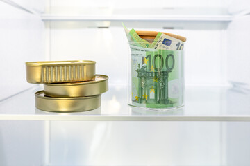 Money, cash euro banknotes in the refrigerator next to food. Concept of saving cash, shadow economy, tax evasion, bad economic decision
