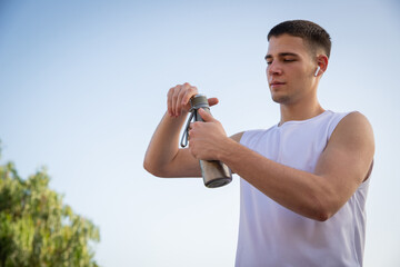 An athlete drinks water during training, concept of hydration during sport.