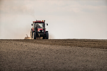 Fototapeta premium The dance of the tractor, cultivating the land in anticipation of new growth