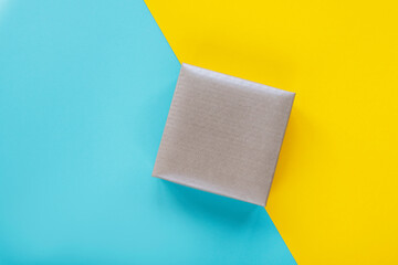Gray box on yellow and blue background. Top view, flat lay, mockup