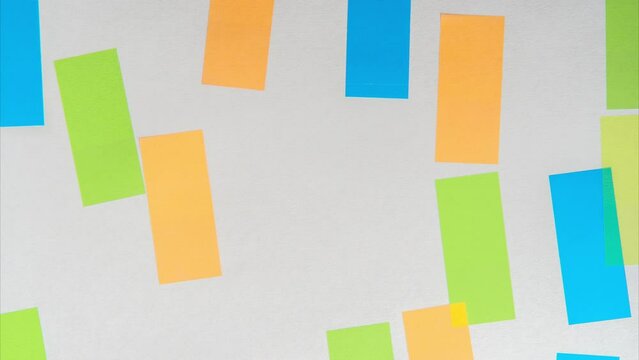 Heap of different colorful transparent self-adhesive sticky paper notes bookmarks reminders stickers covering white background one by one. Office supplies, paper, information. Stop motion. Top view.