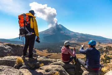 Young man walking on the mountain iztaccihuatl at dawn in the background the popocatepetl volcano © Nailotl