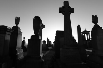 Scotland, Glasgow, United Kingdom - January, 2023: The Necropolis, a cemetery in Glasgow during sunset with illuminated graves and crosses. Cemetery With Tombs And Monuments. 