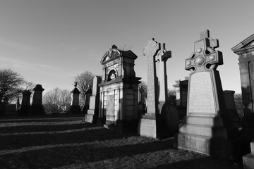 Scotland, Glasgow, United Kingdom - January, 2023: The Necropolis, a cemetery in Glasgow during sunset with illuminated graves and crosses. Cemetery With Tombs And Monuments. 