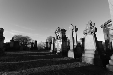 Scotland, Glasgow, United Kingdom - January, 2023: The Necropolis, a cemetery in Glasgow during sunset with illuminated graves and crosses. Cemetery With Tombs And Monuments. 