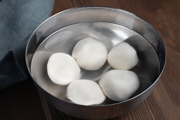Making mozzarella cheese. Cooling the finished balls in cold water