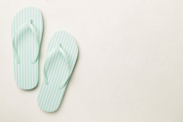 Striped flip flops on concrete background, top view