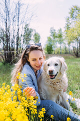 Young beautiful woman and her golden retriever dog having fun in summer