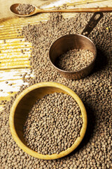 ried lentils scattered on a wooden table with bamboo wooden bowls, spoons and copper dmeasuring container