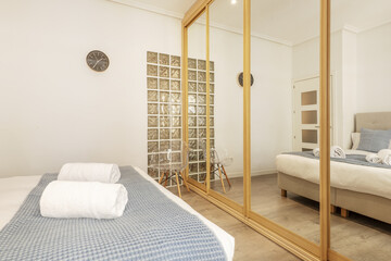 A double bedroom with a large wardrobe covering a wall with oak wood edged sliding mirror doors and...