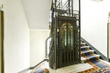 White marble stair area with carpets of a vintage building with the original restored elevator © Toyakisfoto.photos