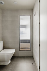 Fototapeta na wymiar Toilet with toilet next to a rectangular translucent glass skylight