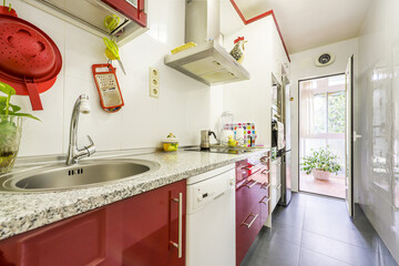 Elongated kitchen with white furniture combined with blue details with white stoneware floors and blue countertop