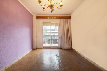 Empty room with walls painted in two colors, old sintasol floors and exit to a terrace with...