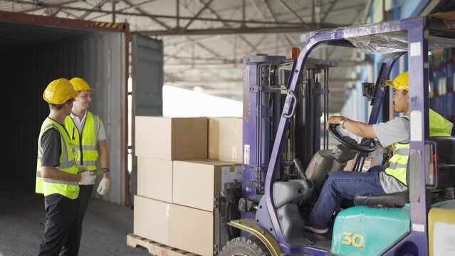 Teamwork of workers driving Fork lift truck with pallet car vehicle in warehouse retail store industry. Rack of stock storage.Cargo in ecommerce and logistic. Depot. People lifestyle. Shipment service