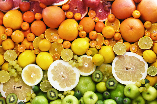 Colorful bright background of fresh ripe sweet citrus fruits: orange and tangerine, green lime and yellow lemon, grapefruit and kumquat