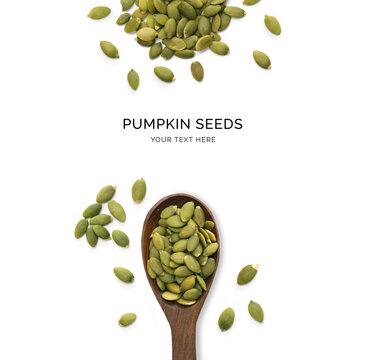 Creative layout made of pumpkin seeds and wood spoon on a white background. Top view.  