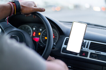 close up of a muckup in a smart phone mobile device into a car, with a hand on steering wheel