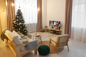 Wide TV set, furniture and Christmas tree in stylish room