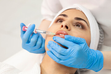 lip augmentation procedure using botox in cosmetology clinic, cosmetologist doctor in gloves makes injection