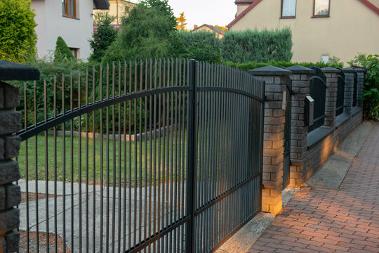 Beautiful brick fence with iron railing outdoors