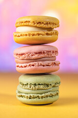 yellow, pink and green macaron cookies, traditional French and Italian gastronomy on colorful background