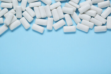 Tasty white chewing gums on light blue background, flat lay. Space for text