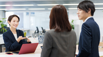 電卓を使ってプレゼンをするビジネスウーマン