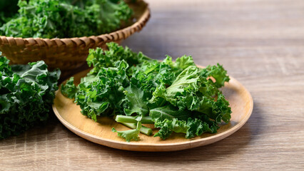 Green Kale or leaf cabbage on wooden plate, Healthy organic vegetable food ingredients