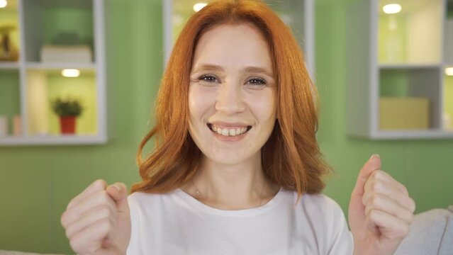 Rejoicing young woman. Young woman looking at laptop rejoices. 
Young woman sitting on the sofa at home is delighted with what she sees on the laptop. Action camera.
