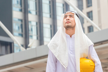 Arab man Construction civil engineer at building construction site, Young Saudi skilled professional engineer