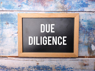 Black wooden board with the word DUE DILIGENCE