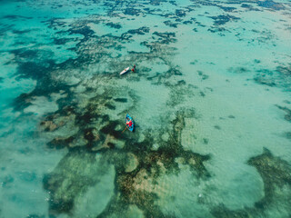 Turquoise water and local fisherman on boat, aerial view in Bali island